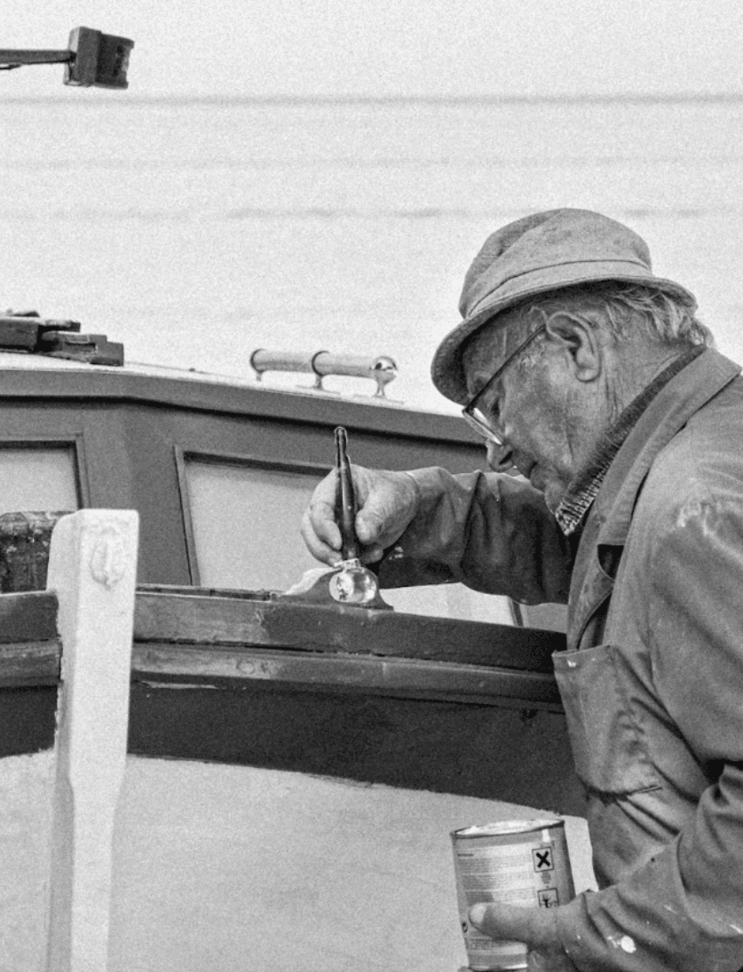 Brian Subrahimi's father painting a boat in Kotor, Montenegro
